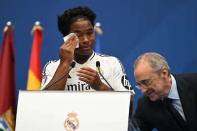 Brazilian forward Endrick Felipe (L) wipes away tears as he stands next to Real Madrid president Florentino Perez during his first appearance as new Real Madrid player at The Santiago Bernabeu Stadium in Madrid on July 27, 2024. (Photo by JAVIER SORIANO / AFP)