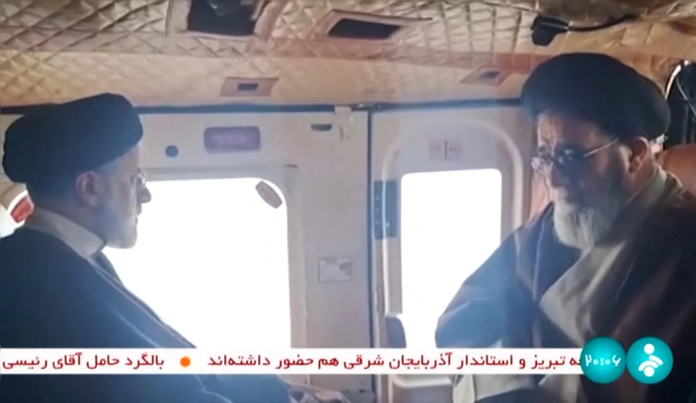 Captura retirada de um vídeo divulgado pela rede de televisão estatal iraniana mostra o presidente do Irã, Ebrahim Raisi (esquerda) em  um helicóptero, em 19 de maio, na região de Jolfa